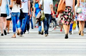 Motion blurred pedestrians crossing sunlit street