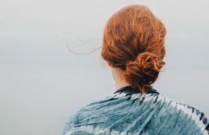 nainen seisoo selkä kameraan